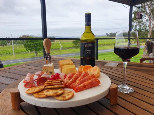 a plate of cheese and crackers and a glass of wine at A Stanthorpe Getaway in Ballandean