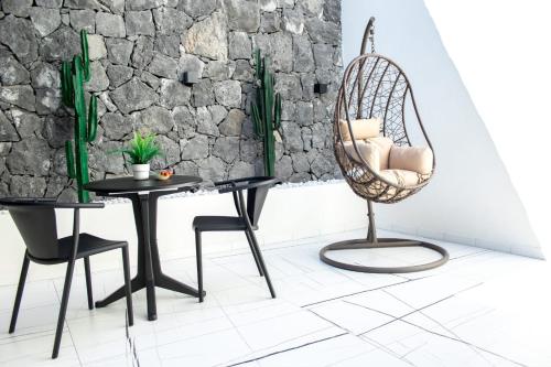 a room with a rattan chair and a table and a chair and a table at Suite Élite in Catania