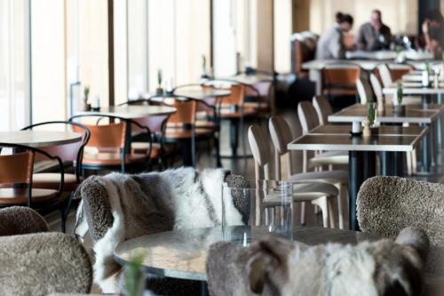 a restaurant with tables and chairs and people in the background at The Wood Hotel by Elite in Skellefteå