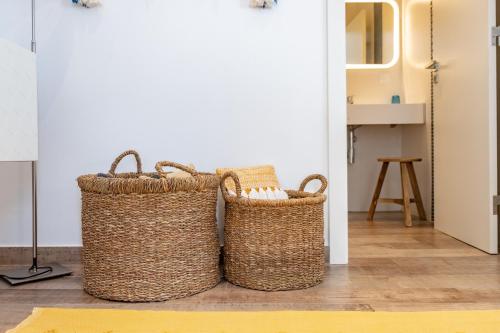 dos cestas sentadas en el suelo en una habitación en Feel Nazaré - Abegoarias 62, en Nazaré