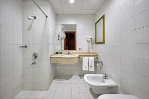 La salle de bains blanche est pourvue d'un lavabo et de toilettes. dans l'établissement Makarem Al Bait Al Azizia Hotel, à La Mecque