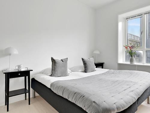ein weißes Schlafzimmer mit einem großen Bett und einem Fenster in der Unterkunft Sanders Fjord - Smart One-Bedroom Apartment In Center of Roskilde in Roskilde
