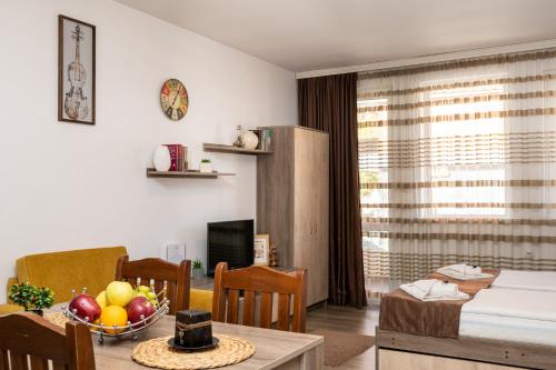 ein Wohnzimmer mit einem Tisch und einer Obstschale in der Unterkunft Luxor Apartment in Welingrad