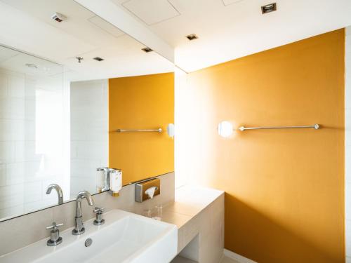 a bathroom with a sink and a mirror at Falkensteiner Hotel Bratislava in Bratislava