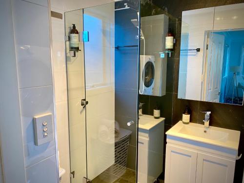 een badkamer met een douche, een wastafel en een toilet bij Relaxing 3 bedroom house with 2 bathrooms. in Katoomba