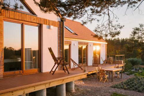 Casa con terraza de madera con mesa y sillas en Nature Home Rybical en Rybical