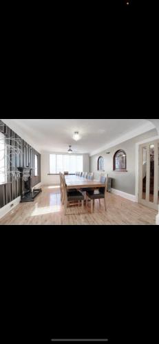 a dining room with a table and chairs in a room at Mansion 8 bedrooms in Private Gated Ave Huge garden Hot tub FREE SAUNA up to 23 in Luton