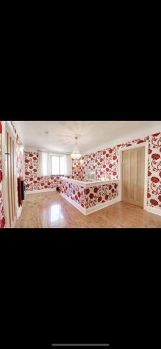 a living room with red and white wall paper at Mansion 8 bedrooms in Private Gated Ave Huge garden Hot tub FREE SAUNA up to 23 in Luton