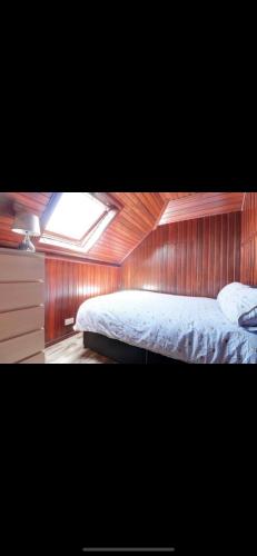 a bedroom with a bed and a skylight at Mansion 8 bedrooms in Private Gated Ave Huge garden Hot tub FREE SAUNA up to 23 in Luton
