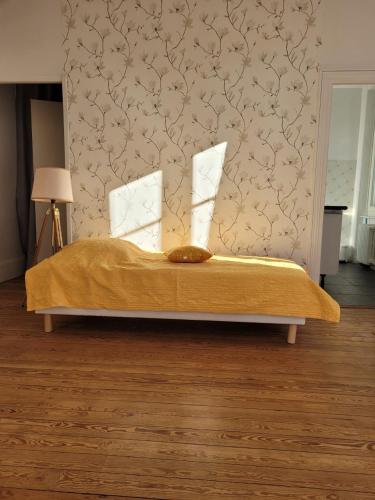 a bedroom with a bed with a yellow comforter at Studio19 in Clermont-Ferrand
