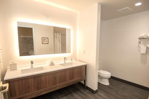 a bathroom with two sinks and a toilet at Holiday Inn Oakland Airport, an IHG Hotel in Oakland