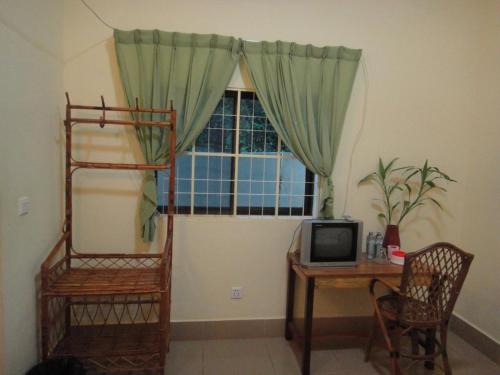 a room with a desk and a window with a computer at Visal Sak Guesthouse in Kep