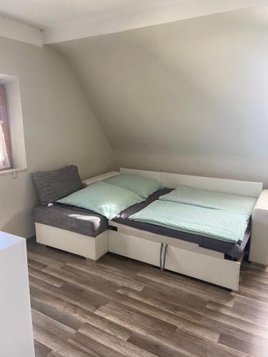 two beds in a small room with wooden floors at Zirndorf Ferienhaus in Zirndorf
