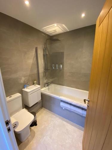 a bathroom with a toilet and a bath tub at Appleacre Accommodation in Winford