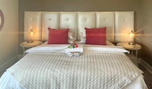 a bedroom with a large bed with red pillows at Eagleview Guesthouse in Hermanus