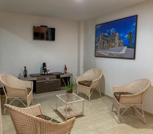 a room with chairs and a desk with a tv at Pousada Talha - Mar in Maragogi