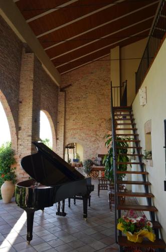 a room with a piano and a spiral staircase at Il Rifugio del Poeta in San Biagio di Callalta