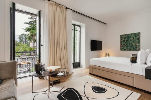 a bedroom with a large bed and a large window at MUSA Lago di Como in Sala Comacina