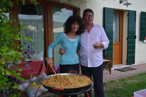 a man and a woman standing next to a large pizza at Il Rifugio del Poeta in San Biagio di Callalta