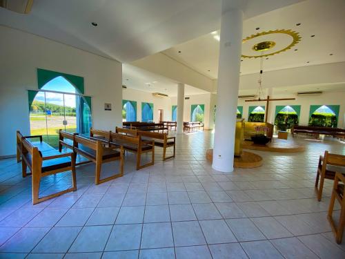 a large room with wooden benches and tables at Hotel Rainha do Brasil in Aparecida