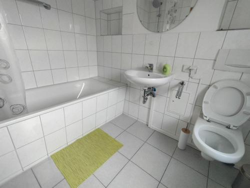 a white bathroom with a sink and a toilet at Apartment für Monteure in Halle (Saale) Mitte in Halle an der Saale
