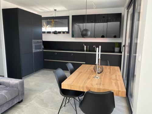 a kitchen with a wooden table and black cabinets at Penthouse Maus in Trogir