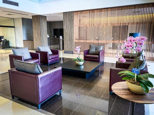 a lobby with couches and chairs and a table at Hotel Rainha do Brasil in Aparecida