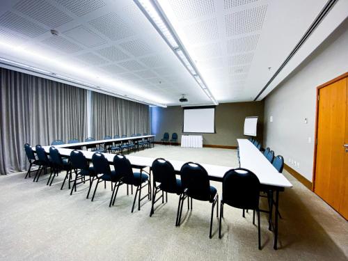 a conference room with a long table and chairs at Hotel Rainha do Brasil in Aparecida