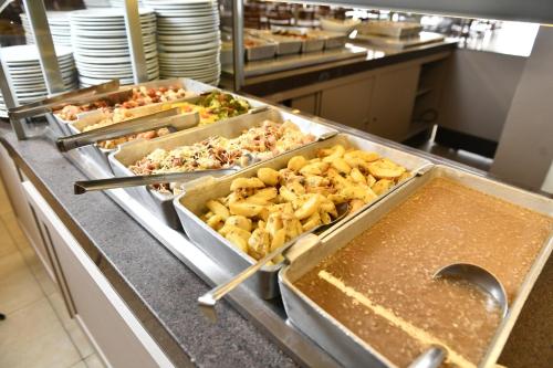 a kitchen with several trays of food on a counter at Hotel Rainha do Brasil in Aparecida