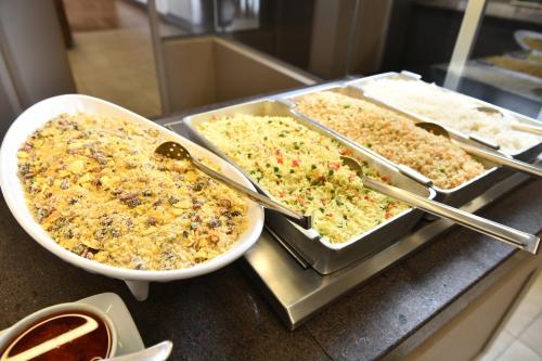 three trays of food on top of a counter at Hotel Rainha do Brasil in Aparecida