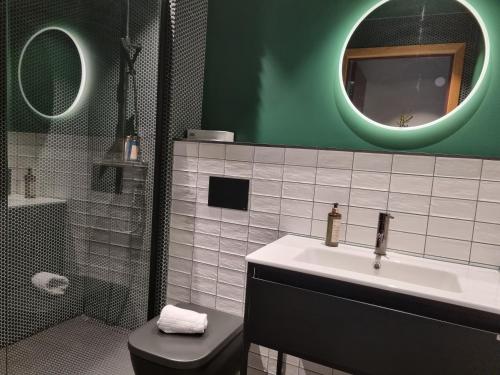 a bathroom with a sink and a toilet and a mirror at Treetop Spa Hangout & Hotel in Gothenburg