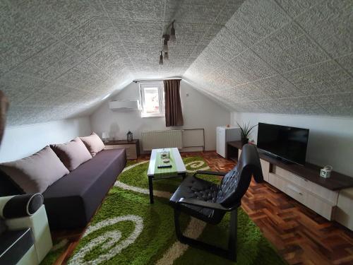 a living room with a couch and a tv at Fortress apartments Niš in Niš