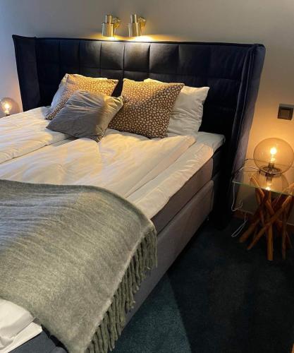 a large bed with a black headboard and pillows at Treetop Spa Hangout & Hotel in Gothenburg