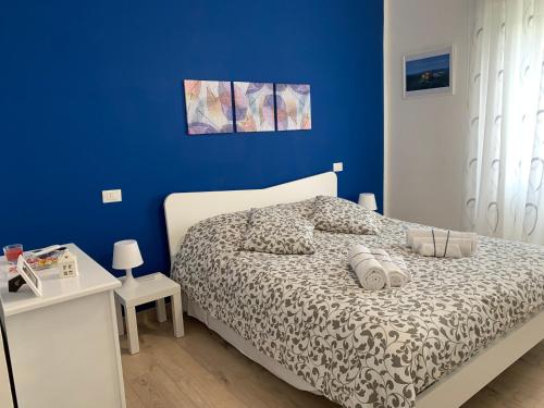 1 dormitorio con 1 cama con pared azul en Casa Elodie, en Bagnoregio