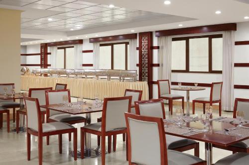 a dining room with tables and chairs and windows at Makarem Mina Hotel in Makkah