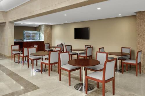 a dining room with tables and chairs and a flat screen tv at Makarem Mina Hotel in Makkah