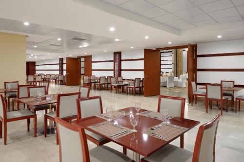 a dining room with wooden tables and chairs at Makarem Mina Hotel in Makkah