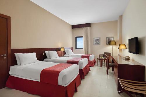 メッカにあるMakarem Mina Hotelのベッド2台とテレビが備わるホテルルームです。