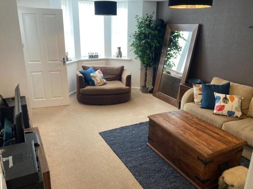 uma sala de estar com um sofá e uma mesa de centro em Cheerful Home FOR FOOTBALL, DOCKS AND CITY CENTRE em Liverpool