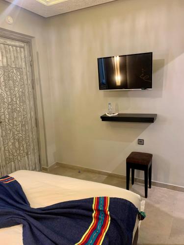 a bedroom with a bed and a flat screen tv on the wall at Villa Margaux in Essaouira