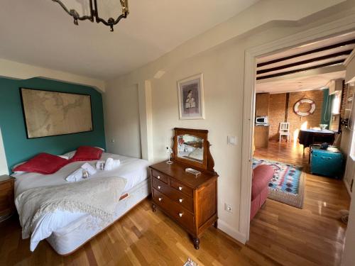 - une chambre avec un lit et une commode avec un miroir dans l'établissement IZARO EYE BERMEO by Urdaibai Rentals, à Bermeo