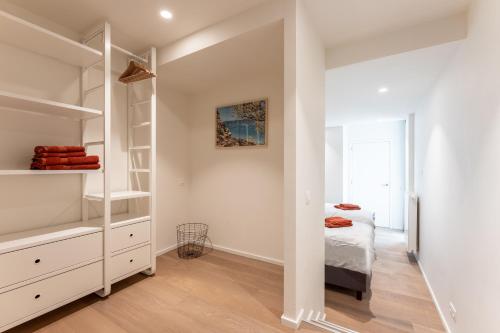 ein weißes Schlafzimmer mit einem Bett und einem Schrank in der Unterkunft Duinenrij 197 in Bredene