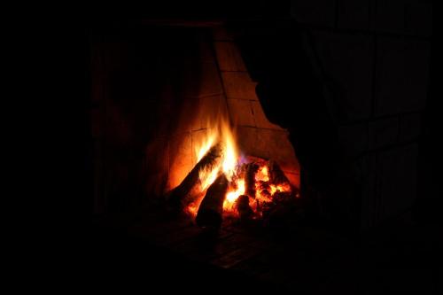 a fire burns in a brick oven in the dark at domek letniskowy Majdy własna plaża in Majdy