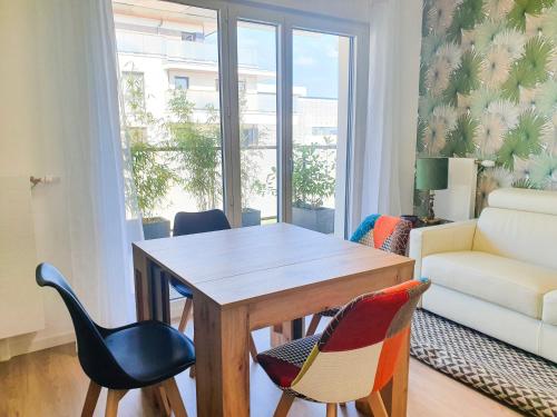 - un salon avec une table et des chaises en bois dans l'établissement EXIGEHOME-Bel appartement de standing-30 minutes de Paris, à Vélizy-Villacoublay