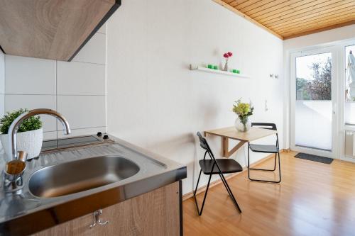 a kitchen with a sink and a table at Blankwasserweg 131 Lensterstrand Oase Bungalow 1 in Lenste