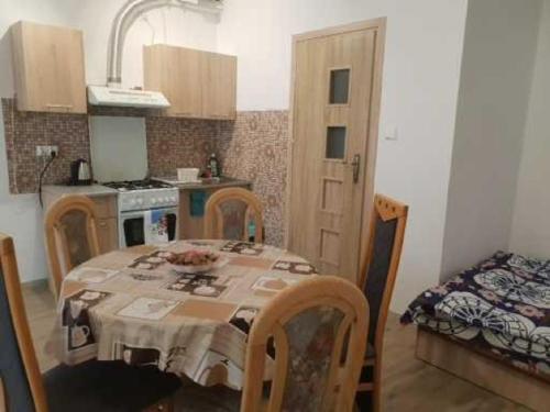 a kitchen with a table and a kitchen with a table and chairs at Noclegi u Dorki in Kurzętnik