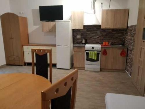 a kitchen with a table and a white refrigerator at Noclegi u Dorki in Kurzętnik