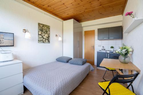 Kleines Zimmer mit einem Bett, einem Schreibtisch und einer Küche in der Unterkunft Blankwasserweg 131 Lensterstrand Oase Bungalow 3 in Lenste