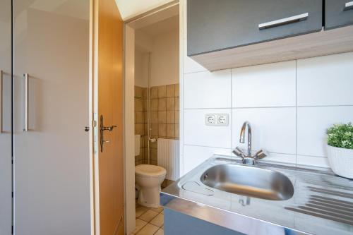 a bathroom with a sink and a toilet at Blankwasserweg 131 Lensterstrand Oase Bungalow 3 in Lenste