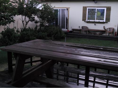 a wooden picnic table in front of a house at Gyeongju Momojane Guesthouse in Gyeongju